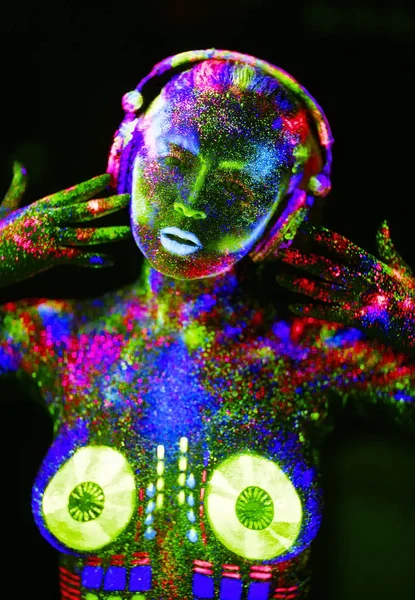 Concepto. En el cuerpo de una chica pintó la cubierta de DJ. Chica semidesnuda pintada en colores UV — Foto de Stock