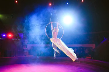 Hava acrobat içinde belgili tanımlık çalmak. Genç bir kız akrobatik öğeleri hava ringde gerçekleştirir.