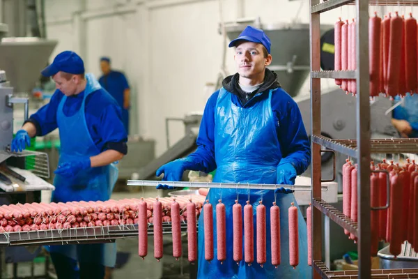 Ritratto di macellai che lavorano salsicce in fabbrica di carne . — Foto Stock