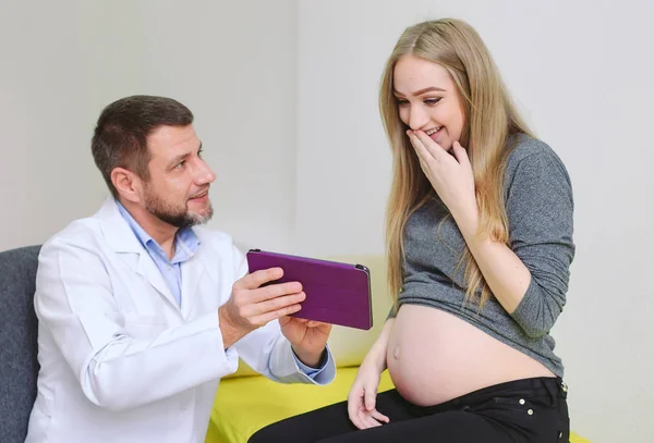 Гинеколог показывает эхо-фото беременной женщине — стоковое фото