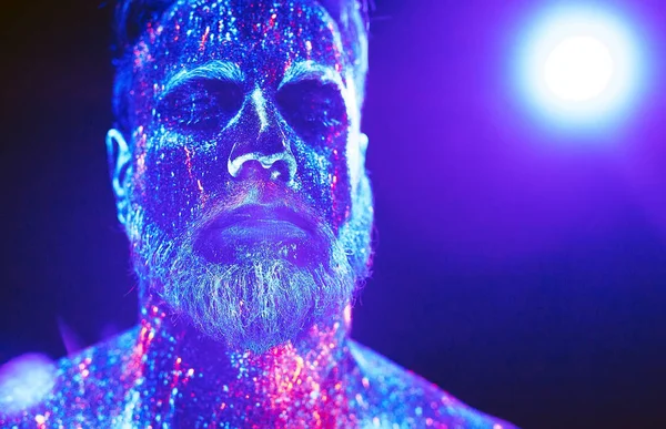 Концепция. Портрет бородатого человека. Человек окрашен в ультрафиолетовый порошок — стоковое фото