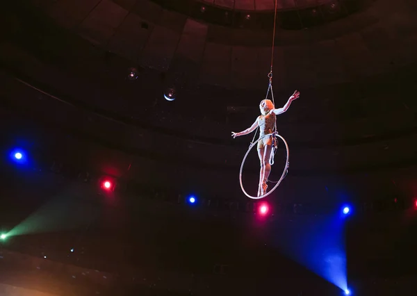 Luchtfoto acrobat in de ring. Een jong meisje voert de acrobatische elementen in de ring van lucht — Stockfoto