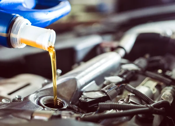 Aceite de motor que vierte al motor del coche. Una estación de servicio . —  Fotos de Stock