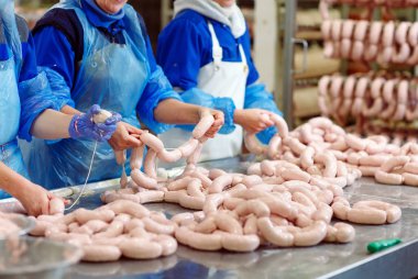 Kasaplar et fabrikasında sosis işliyor.