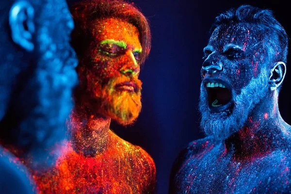 Floresan tozuyla boyanmış üç sakallı adamın portresi.