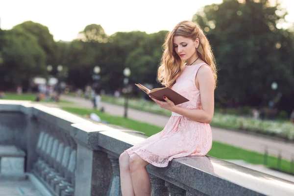 Genç kız parkta kitap okuyor. — Stok fotoğraf