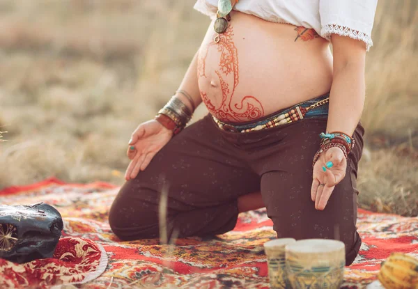 Schwangere beim Yoga auf dem Feld bei Sonnenuntergang — Stockfoto