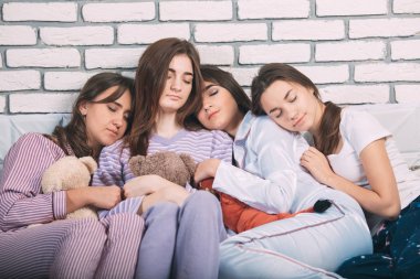 Yatakta uyuyan bir grup genç insan..