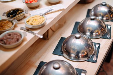 Restoranda ya da otelde açık büfe. Kapaklı metal kaplar.