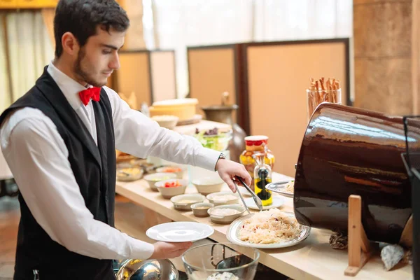 Crauti. Colazione in hotel o al ristorante. Il cameriere depone i crauti nel piatto. — Foto Stock