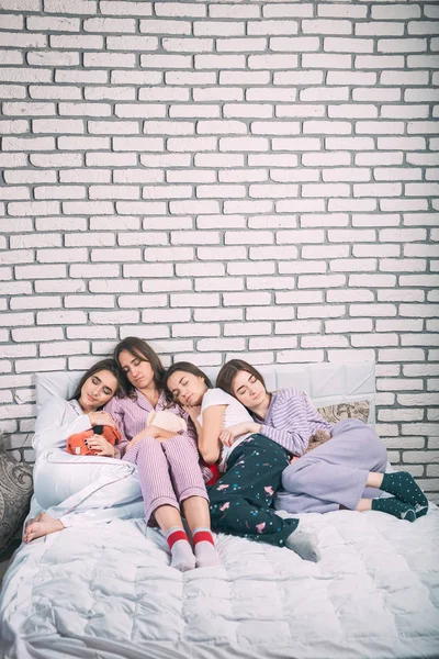 Sleeping group of young people on the bed. — Stock Photo, Image
