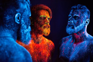 Floresan tozuyla boyanmış üç sakallı adamın portresi.