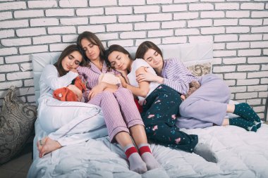 Yatakta uyuyan bir grup genç insan..