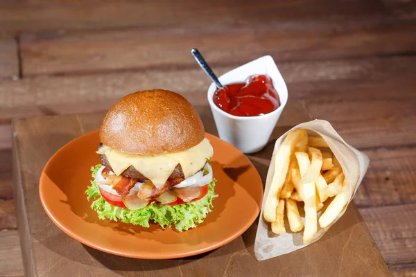 Burger and french fries on the wooden table. — Stock Photo, Image