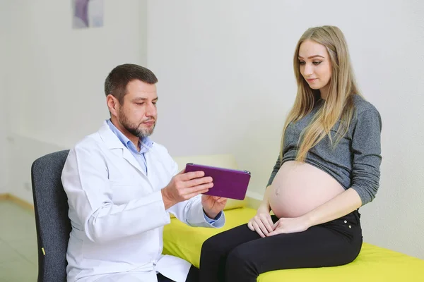 Gynecologist showing echo photo to pregnant woman — Stock Photo, Image