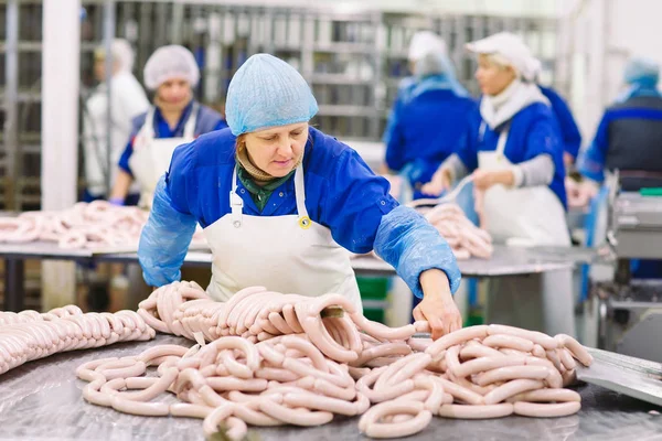 Slaktare som bearbetar korv på meatfabriken. — Stockfoto