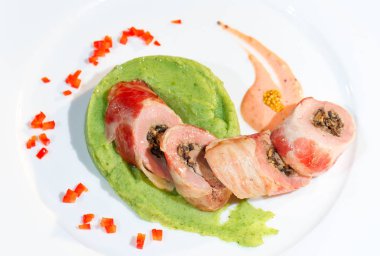 Ahşap bir masanın arka planında beyaz bir tabak üzerinde brokoli püresi ile domuz bonfile.