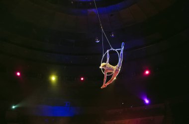 Hava acrobat içinde belgili tanımlık çalmak. Genç bir kız akrobatik öğeleri hava ringde gerçekleştirir..