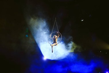Hava acrobat içinde belgili tanımlık çalmak. Genç bir kız akrobatik öğeleri hava ringde gerçekleştirir..