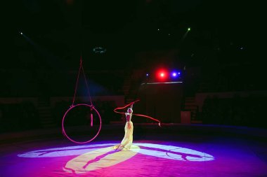 Hava acrobat içinde belgili tanımlık çalmak. Genç bir kız akrobatik öğeleri hava ringde gerçekleştirir..