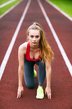 Bir yarış pistinde güzel atlet koşmaya hazır.