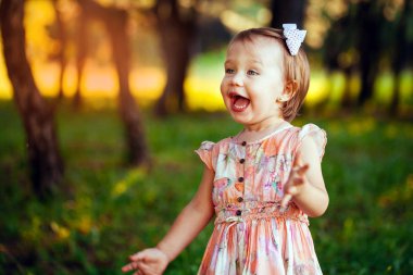 Açık yaz gününde gülümseyen sevimli küçük kız portresi.