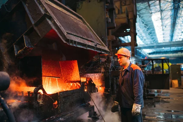 Trabalhadores na siderurgia. Trabalhador da fábrica tira uma amostra de metal . — Fotografia de Stock