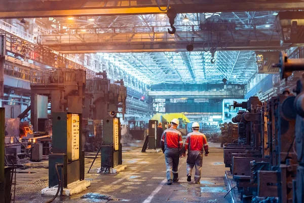 Trabalhadores na siderurgia. Trabalhador da fábrica tira uma amostra de metal . — Fotografia de Stock