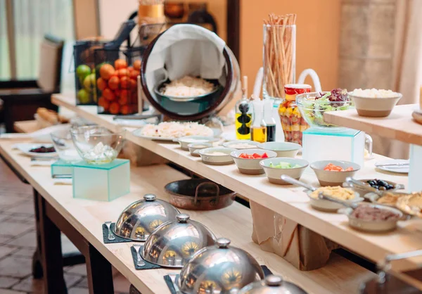 Buffet in een restaurant of hotel. Metalen schotels met dop. — Stockfoto