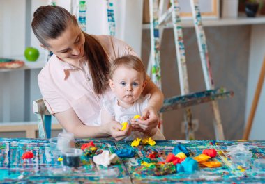 Kinetik kumla oynayan anne ve kızı.