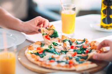 Bir çift bir restoranda pizza yiyor.