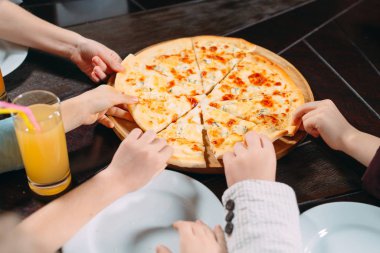 Ahşap masada Pizza dilimleri alarak eller, yakın görünüm