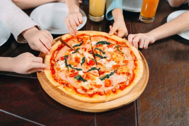 Ahşap masada Pizza dilimleri alarak eller, yakın görünüm