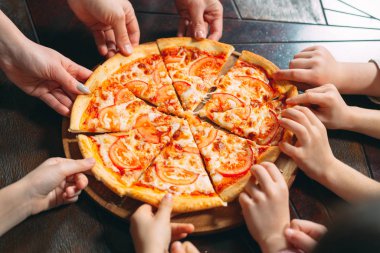 Ahşap masada Pizza dilimleri alarak eller, yakın görünüm.