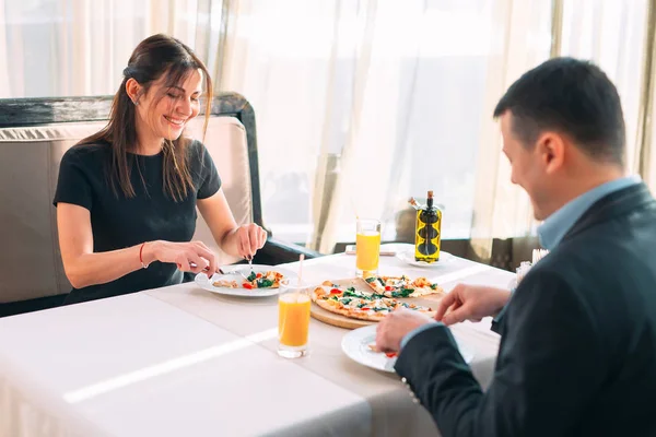 Ένα ζευγάρι τρώει πίτσα σε ένα εστιατόριο. — Φωτογραφία Αρχείου