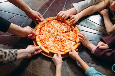 Ahşap masada Pizza dilimleri alarak eller, yakın görünüm.