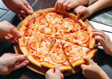Ahşap masada Pizza dilimleri alarak eller, yakın görünüm.