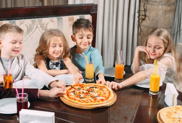 lovely children eat pizza in the restaurant