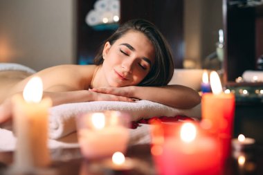 Spa, masaj. Genç, siyah saçlı güzel bir kız masaj bekliyor..