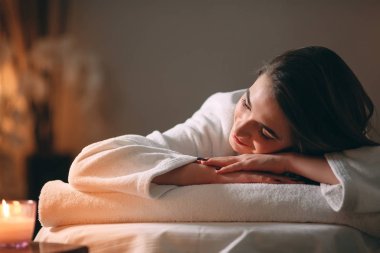 Spa, masaj. Genç, siyah saçlı güzel bir kız masaj bekliyor..