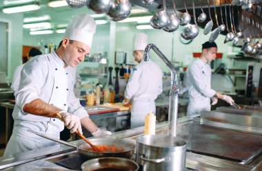 Modern mutfak. Aşçılar restoranın ya da otelin mutfağındaki ocakta yemek hazırlarlar. Mutfaktaki yangın..
