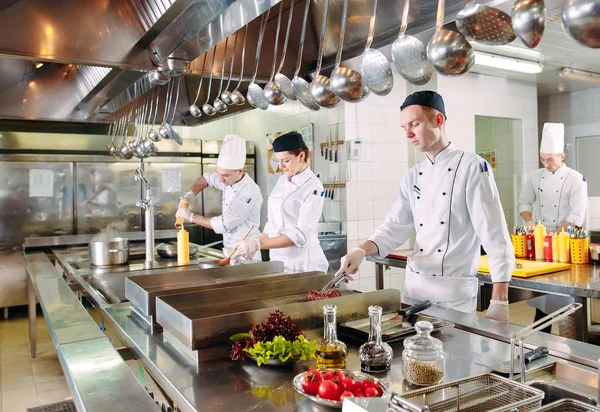 Moderne Küche. Köche bereiten die Mahlzeiten auf dem Herd in der Küche des Restaurants oder Hotels zu. Das Feuer in der Küche. — Stockfoto