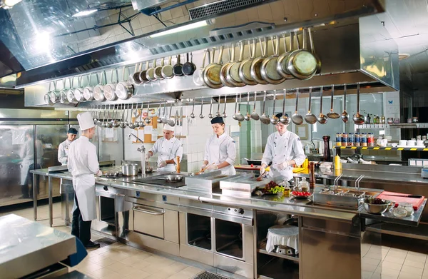 Cocina moderna. Los cocineros preparan comidas en la estufa en la cocina del restaurante u hotel. El fuego en la cocina. — Foto de Stock