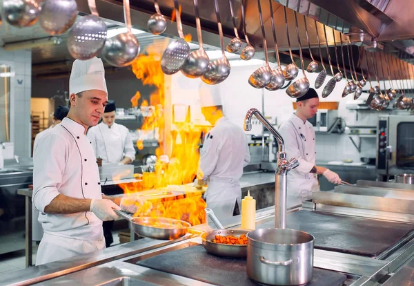 Nowoczesna kuchnia. Kucharze przygotowują posiłki na piecu w kuchni restauracji lub hotelu. Pożar w kuchni.. — Zdjęcie stockowe