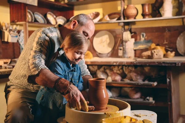 Atelier de poterie. Grand-père enseigne la poterie à petite-fille. Modélisation de l'argile — Photo