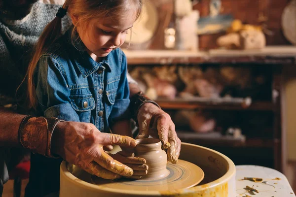 Керамическая мастерская. Дедушка преподает керамику внучке. Моделирование глины — стоковое фото