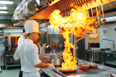 Modern mutfak. Aşçılar restoranın ya da otelin mutfağındaki ocakta yemek hazırlarlar. Mutfaktaki yangın..