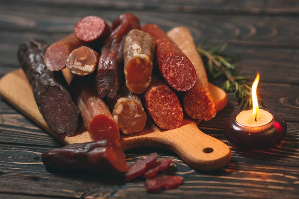 Różne rodzaje kiełbas i wyrobów mięsnych na drewnianej desce — Zdjęcie stockowe