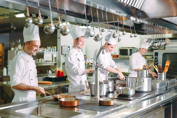 Chef cocinando verduras en sartén wok. Dof poco profundo. — Foto de Stock