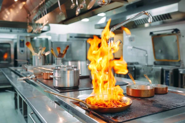 Cocina moderna. Los cocineros preparan comidas en la estufa en la cocina del restaurante u hotel. El fuego en la cocina. — Foto de Stock